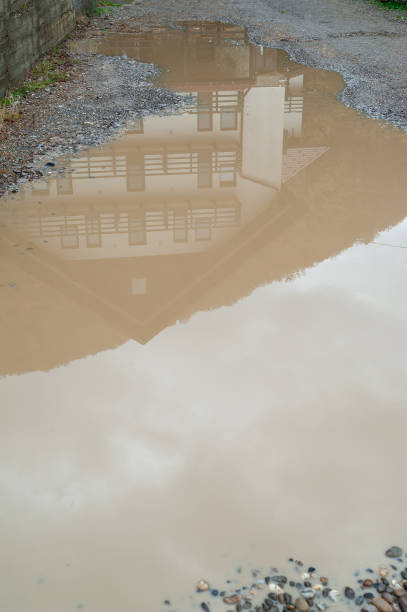 istock Dirty puddle. Reflection in a puddle. Muddy puddle with clay and stones 2188098576
