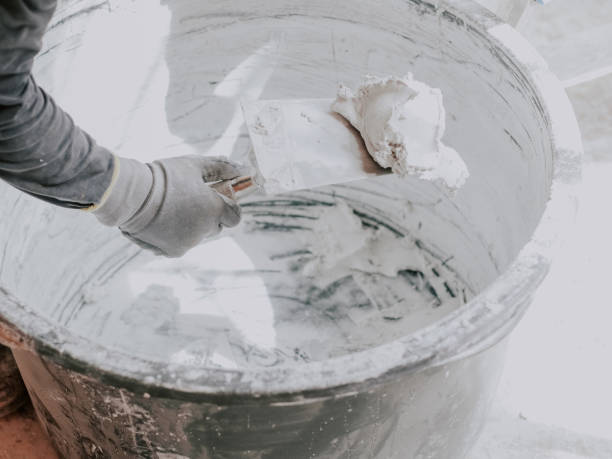 istock A young plasterer scoops up putty from a basin with a spatula. 2188101218
