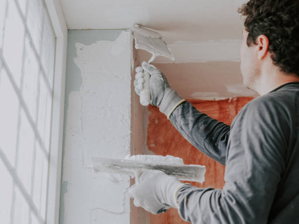 istock A young man is putting putty on a window opening. 2188102487