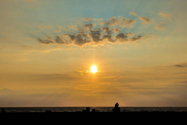 A clear and warm summer's evening as the sun goes down everything is silhouetted against the warm colours of the sky as the sun disappears.