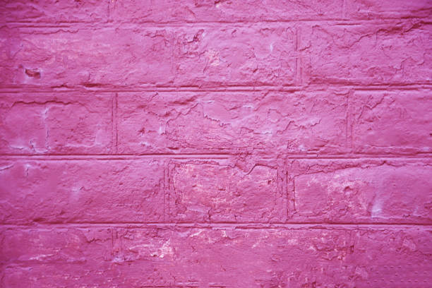 Fragment of the facade of a brick wall of an old coral-colored building.