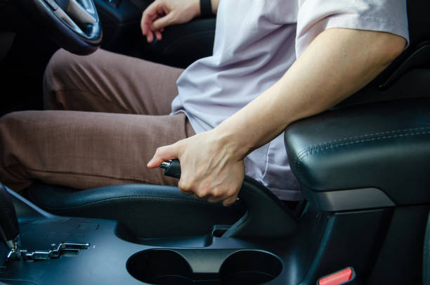 istock female driver's hand pulling hand brake lever. Handbrake in car. 2188124256