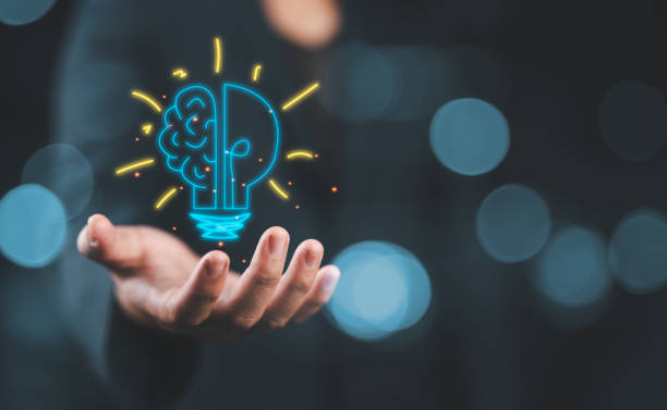 istock Hand holding drawing virtual lightbulb with brain on bokeh background for creative and smart thinking idea concept. 2188124581
