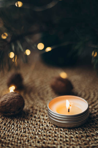istock Burning candle, nuts and Christmas tree branches on a blurred bokeh background. 2188126236