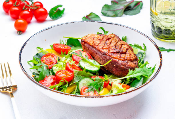 istock Salad with duck breast, lettuce and vegetables, white background, top view 2188126314