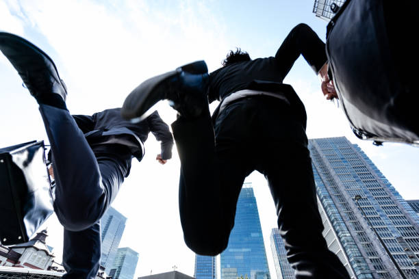 istock A dynamic image that looks up at two businessmen men from low angles in a blue sky business district 2188129405