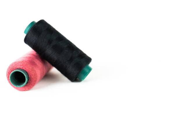 istock two spools of thread, one pink and one black with needle threaded with pink on white background 2188132554