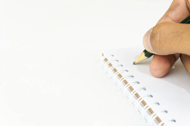 istock person's hand writing with a pencil on a blank spiral notebook on white background 2188133846