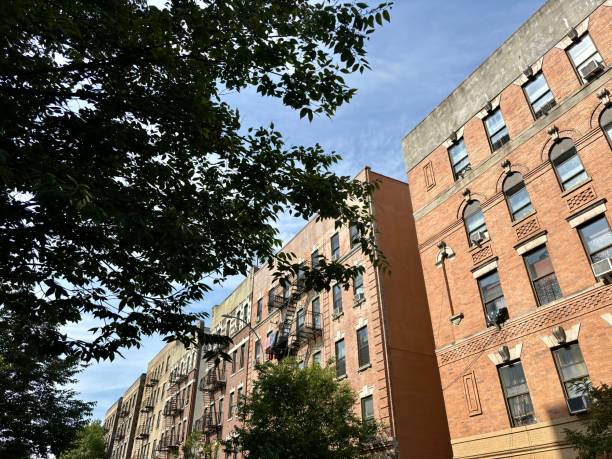 istock Row of brick apartment buildings with fire escapes under blue sky 2188133849