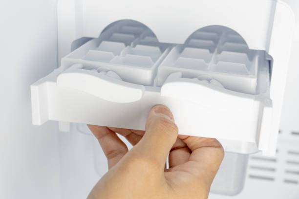 istock a hand hold ice tray and try to making ice cubes in freezer. 2188133989