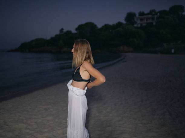 istock Woman dressing up in a summer beach at night 2188134477