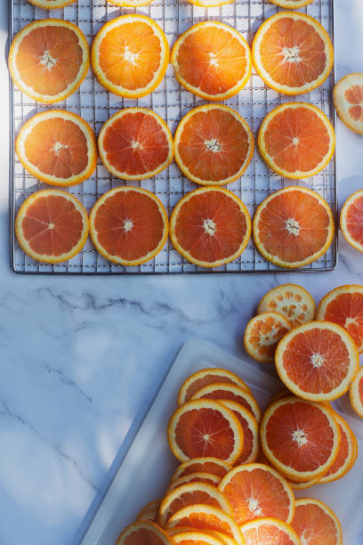 istock orange slices in preparation to make decorative dried oranges on dehydrator rack. 2188138884