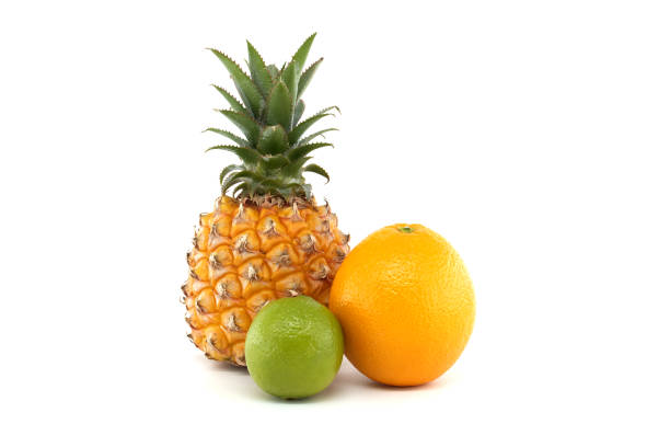 A vibrant assortment of tropical fruits including pineapple, orange, and lime against a white background. Ideal for concepts of freshness, summer, and healthy eating