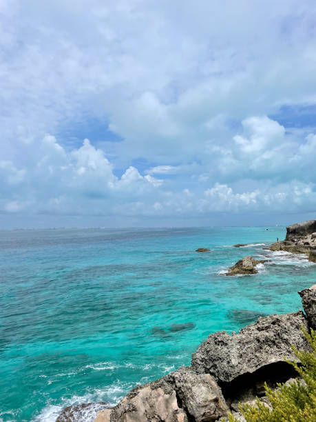 istock Crystal clear turquoise waters along a rugged rocky coastline under blue skies 2188141159