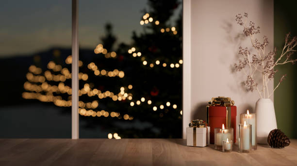 istock Copy space for product display on a wooden surface, overlooking a glowing Christmas tree outside. 2188141325
