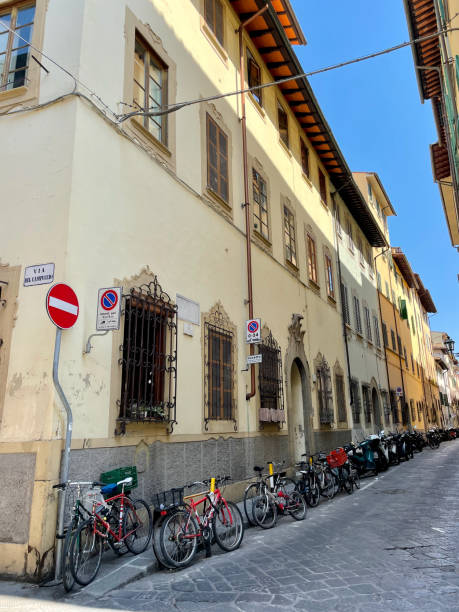 Quaint Florence street lined with bicycles under a clear blue sky