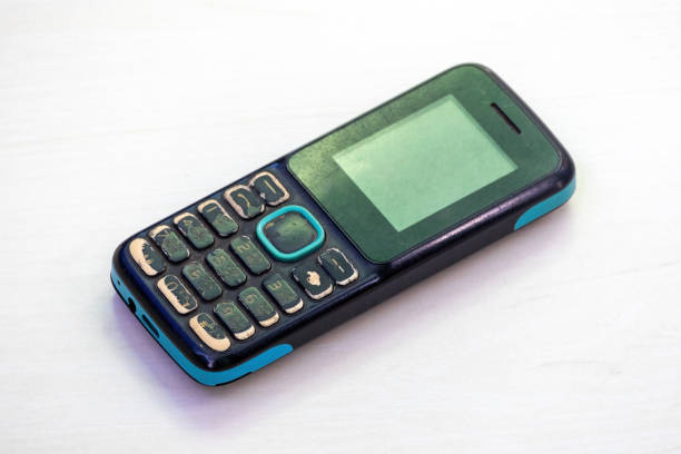 istock An old, used button-style mobile phone, isolated on a white background. 2188146859