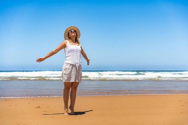 istock Beautiful mature woman walking on sandy beach. Front view 2188149891