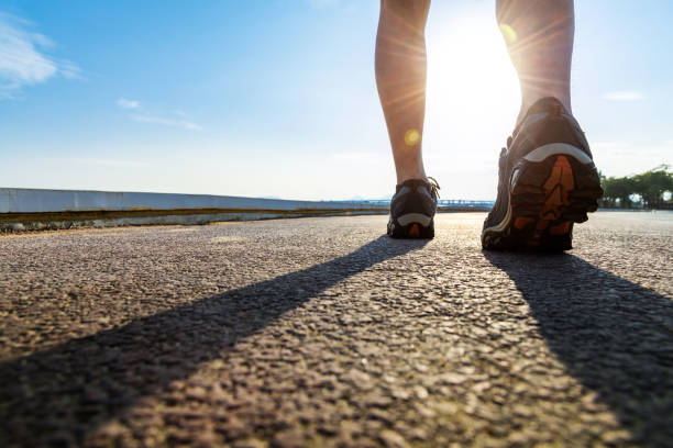 Runner feet and shoes on tracks with blue sky background