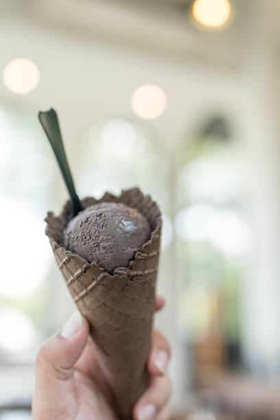 istock A young man is holding an chocolate ice cream on charcoal waffle cone 2188152449