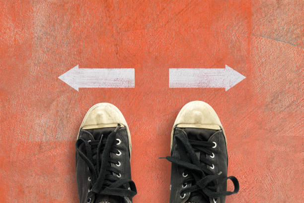istock people standing behind left and right arrow direction to choose 2188152888