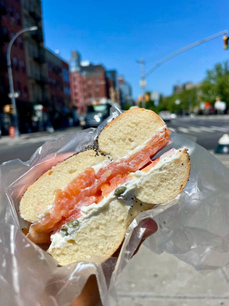 Fresh salmon bagel held on a sunny New York street