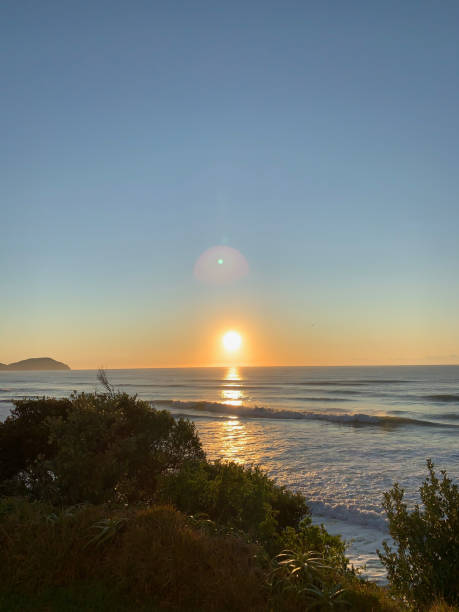 istock Golden sunrise over a tranquil beach with gentle ocean waves 2188153591