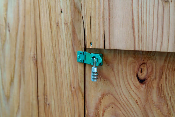 Rusty lock, hasp and staple on a wooden farmyard barn door.