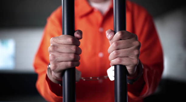istock Prisoner Behind Bars In Jail Cell. Crime Punishment 2188158281