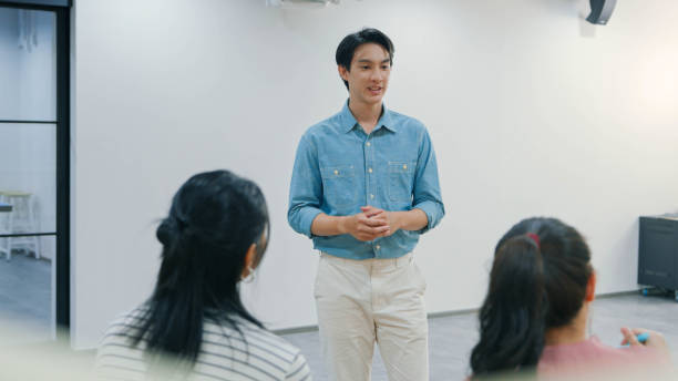 A confident young leader engages his team in a collaborative discussion in a bright modern office. Perfect for themes of leadership, teamwork, and productivity.