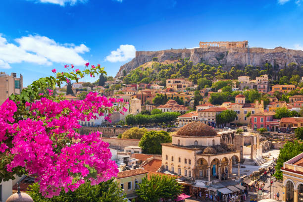 skyline di atene con piazza monastiraki e collina dell'acropoli durante il tramonto. atene, grecia. fiore di bouganville rosa in primo piano - acropoli atene immagine foto e immagini stock
