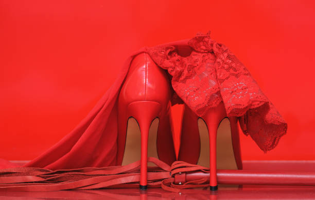 istock red high heels and whip on red background 2188167947