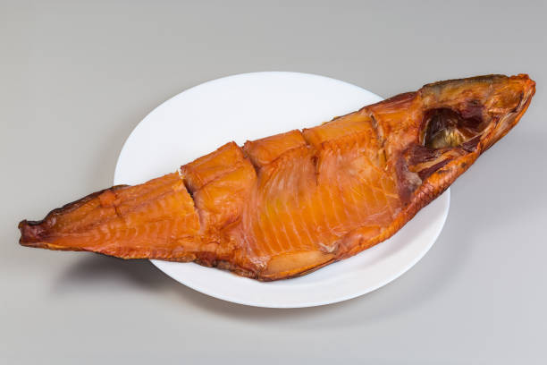 Smoked pink salmon on plate isolated on white background. Top view, close-up.