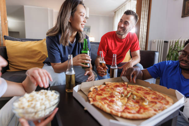 istock Group of young people enjoying pizza at home 2188172755