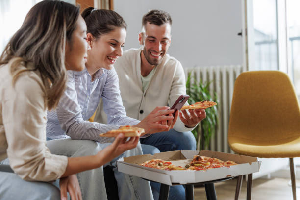 istock Friends eating pizza, socializing and having fun at home 2188173016