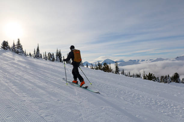 Ski mountaineer ascends ski track at resort