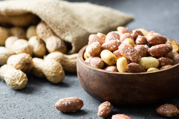Peanut with nutshell not peeled nut on rustic background, composition of peanuts, concept of nuts