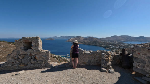 Woman stands in ruins above sea, Leros