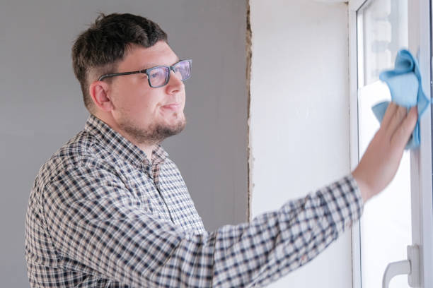 istock man cleaning a window at home. spring cleaning. 2188179496