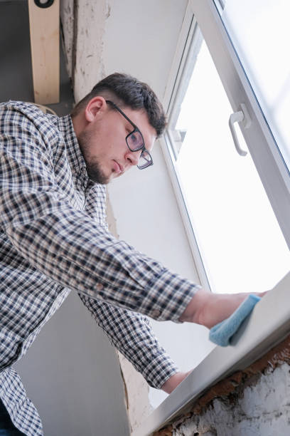 istock man cleaning a window at home. spring cleaning. 2188179529
