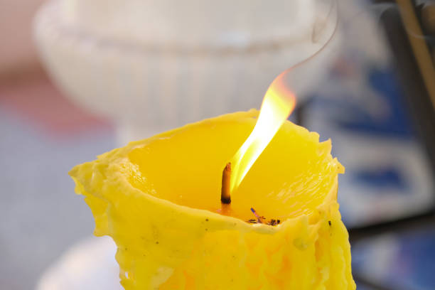 The candle flame is blown to the right by the wind.