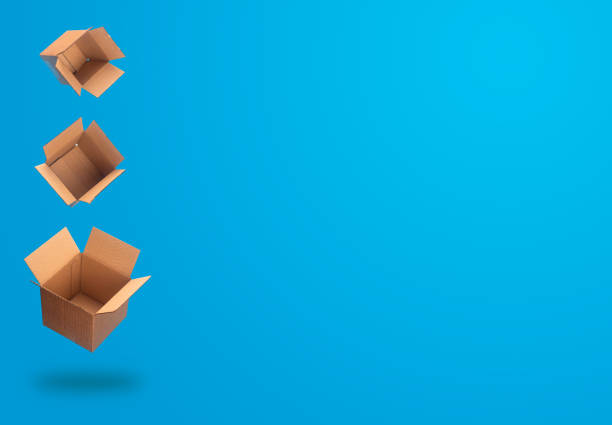 Delivery and shipping concept. Three levitating flying opened cardboard boxes against blue background. Free space for your text.