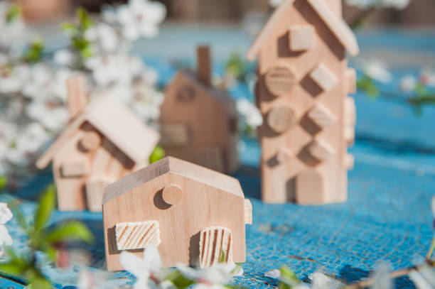 Wooden Toy Houses with Blossoms on Blue Rustic Surface