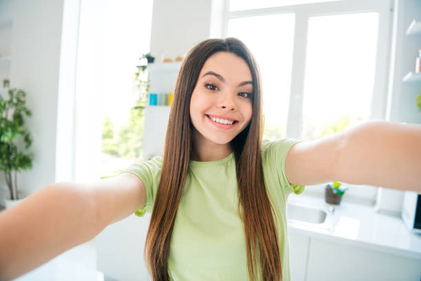 istock Happy young woman taking a selfie in bright kitchen during daytime 2188189132