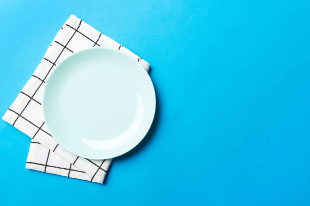 istock Top view on colored background empty round blue plate on tablecloth for food. Empty dish on napkin with space for your design 2188189533