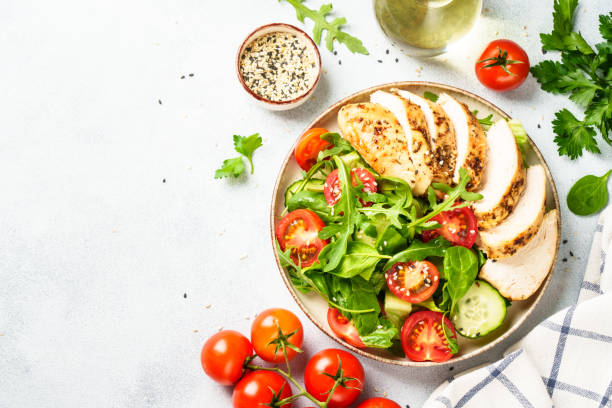 istock Green salad with grilled chicken meat at white table. 2188189958