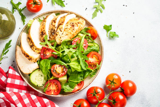 istock Green salad with grilled chicken meat at black table. 2188189959