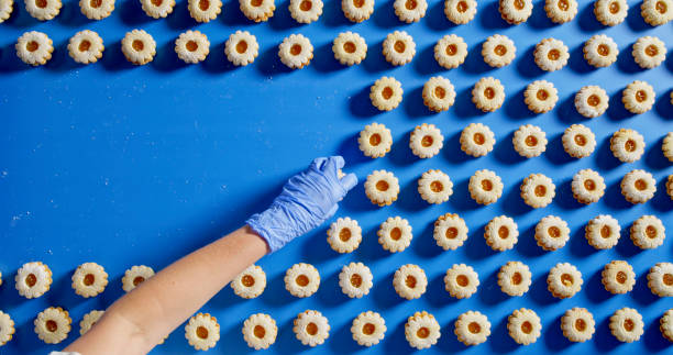 istock Cookie Arrangement on Conveyor with Gloved Hand 2188189961