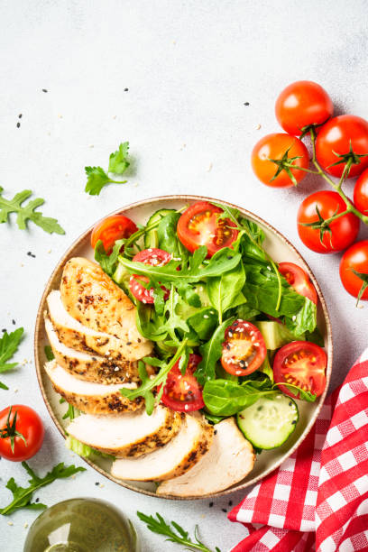 istock Green salad with grilled chicken meat at white table. 2188189964
