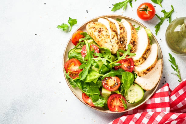 istock Green salad with grilled chicken meat at black table. 2188189966